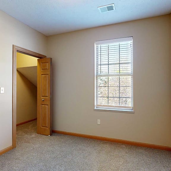 Thumbnail 26 of 32 a bedroom with a window and a door to a walk-in closet