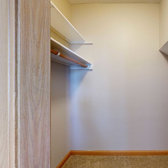 Thumbnail 27 of 32 a walk-in closet with a built-in shelf and an angled alcove
