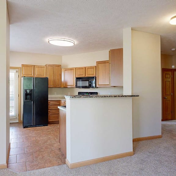 Thumbnail 9 of 32 a kitchen with a black refrigerator and a counter top