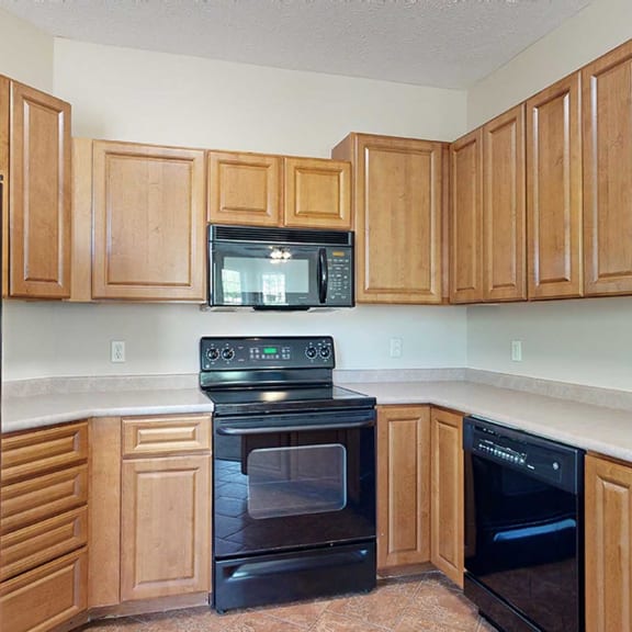Thumbnail 10 of 32 a kitchen with warm wooden cabinets and black appliances