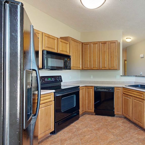 Thumbnail 11 of 32 a kitchen with black appliances and wooden cabinets