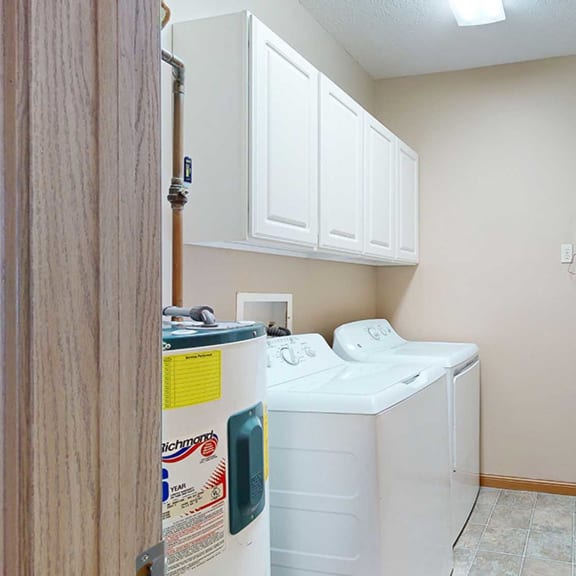 Thumbnail 31 of 32 a laundry room with side-by-side washer and dryer and overhead storage