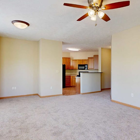Thumbnail 8 of 32 a living room with a ceiling fan next to a kitchen countertop