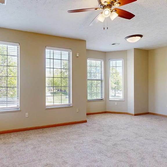 Thumbnail 5 of 32 a living room with a ceiling fan, several windows, and a fireplace