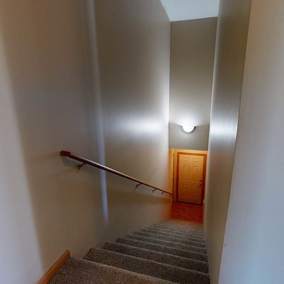Thumbnail 2 of 32 a staircase with a rail and a wooden door at the bottom