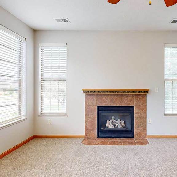 Thumbnail 8 of 39 A living room with a fireplace and several windows.