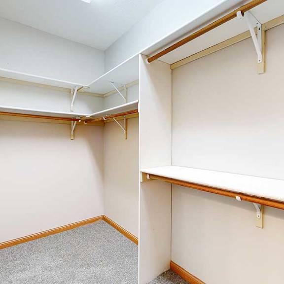 Thumbnail 27 of 39 A long walk-in closet with several built-in shelves and hanging space.