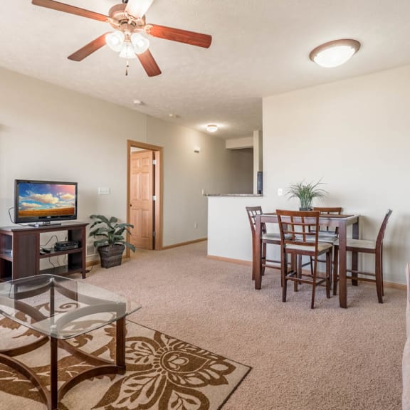 Thumbnail 7 of 12 a living room and dining room with a table and a ceiling fan