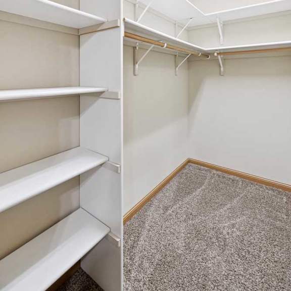 Thumbnail 17 of 23 Spacious walk-in closet with built-in shelving and double hanging rods.