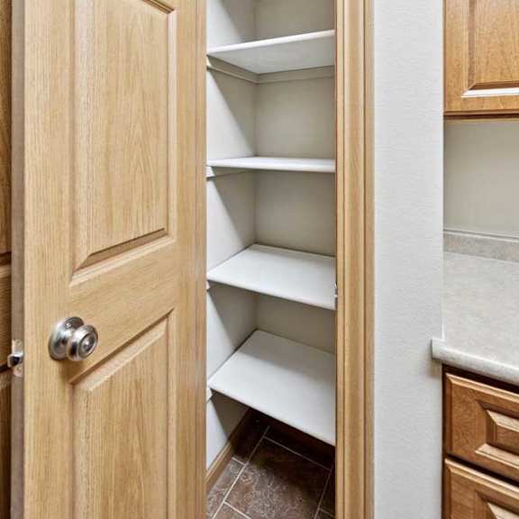 Thumbnail 9 of 23 Pantry closet with built-in shelving and wood door for additional kitchen storage.