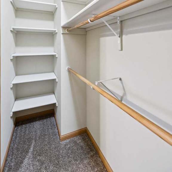 Thumbnail 17 of 19 Walk-in bedroom closet with built-in shelving and dual hanging rods for organized storage.