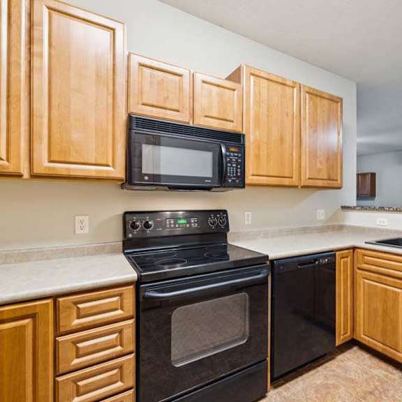 Thumbnail 11 of 19 Kitchen with black oven, built-in microwave, dishwasher, and double-basin sink with laminate countertops.