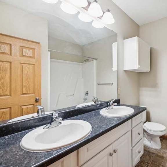 Thumbnail 18 of 19 A bathroom with two sinks and a toilet.