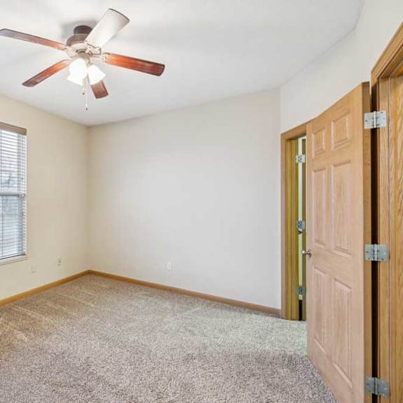 Thumbnail 14 of 19 Bedroom with plush carpet, large window with blinds, ceiling fan, and neutral finishes.