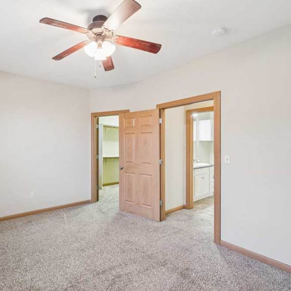Thumbnail 15 of 19 A room with a ceiling fan and a door.