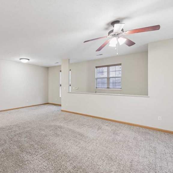 Thumbnail 10 of 19 Open-concept living and dining area with plush carpet, ceiling fan, breakfast bar, and neutral finishes throughout.