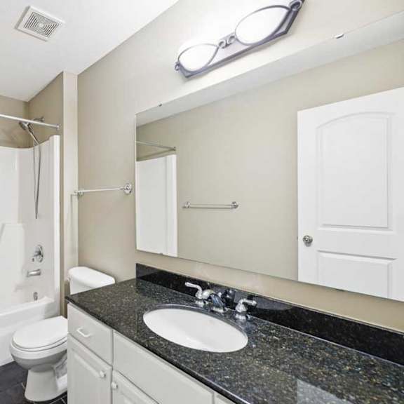 Thumbnail 20 of 26 Full bathroom with tub/shower combo, granite vanity countertop, and tile flooring.