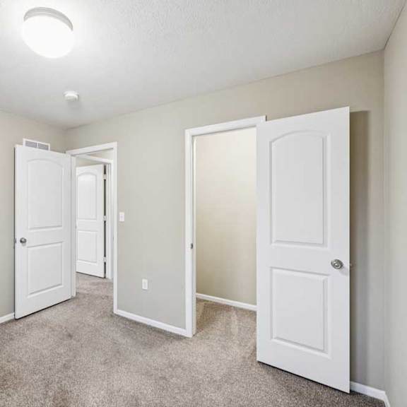 Thumbnail 17 of 26 Bedroom with neutral carpet, double-door closet, and adjacent hall access.
