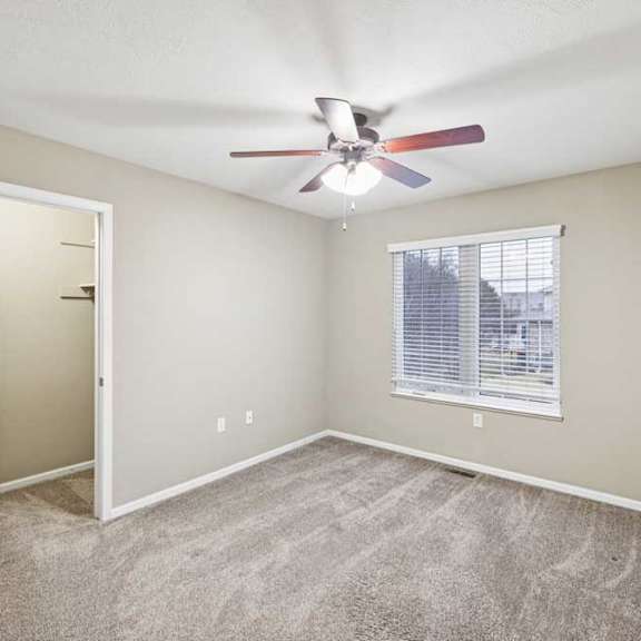 Thumbnail 19 of 26 Secondary bedroom featuring ceiling fan, large window with blinds, and dual closets.