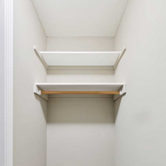 Thumbnail 18 of 26 Walk-in closet with built-in shelving and hanging rod.