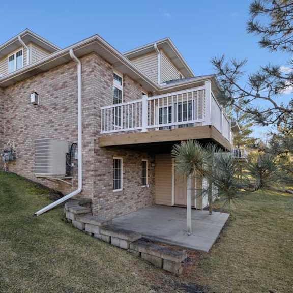 Thumbnail 26 of 26 Rear exterior with brick façade, elevated deck, and covered patio below.