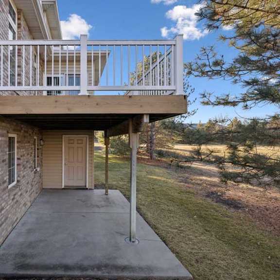 Thumbnail 25 of 26 Covered lower-level patio with concrete slab and backyard views.