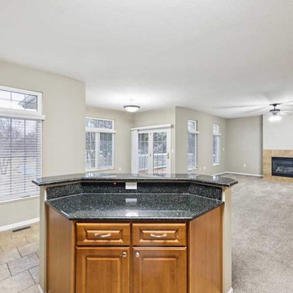 Thumbnail 6 of 26 Open living and dining area with large windows, sliding glass door to deck, and corner fireplace.