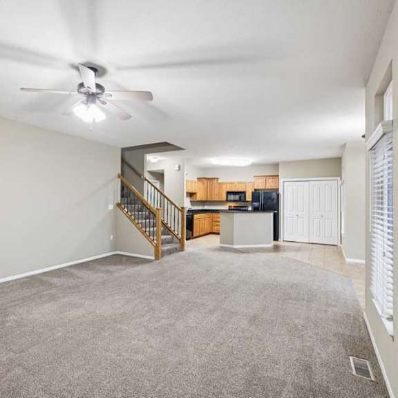 Thumbnail 11 of 26 Expansive open-concept apartment interior with carpeted living space, tile entry, and peninsula kitchen.