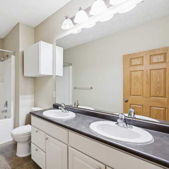 Thumbnail 17 of 20 Full bathroom with double-sink vanity, large mirror, overhead lighting, tub and shower combination, and tile-look flooring.