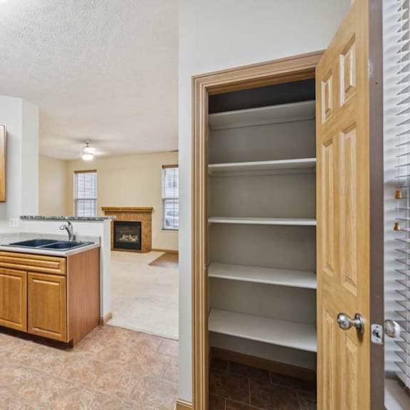 Thumbnail 7 of 20 Kitchen with open pass-through to living area and adjacent pantry closet with built-in shelving.