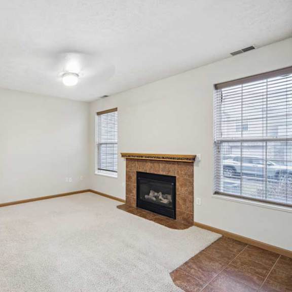 Thumbnail 9 of 20 Living area with corner fireplace, large windows, and open layout connecting to dining space.