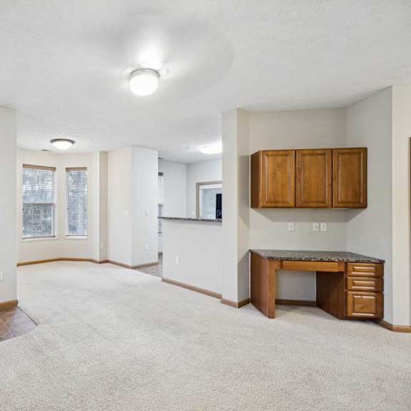 Thumbnail 3 of 20 Open-concept living and dining area with built-in desk, upper cabinets, and breakfast bar.