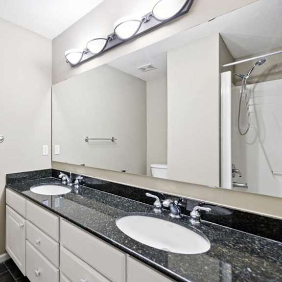 Thumbnail 18 of 25 Full bathroom with double-sink vanity, granite countertop, large mirror, and tub and shower combination.
