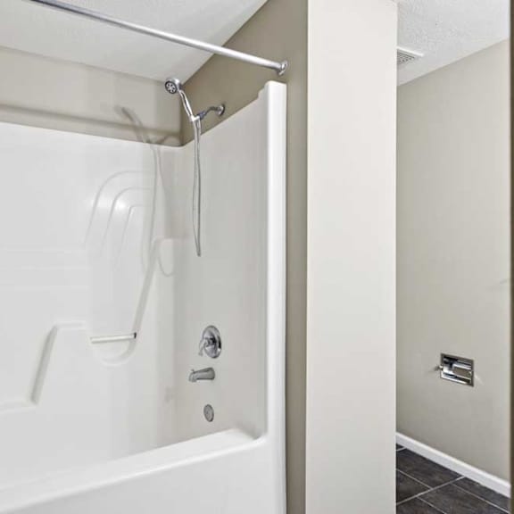 Thumbnail 19 of 25 Tub and shower combination with built-in surround and chrome fixtures.