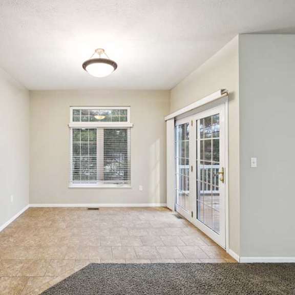 Thumbnail 6 of 25 Dining area with tile flooring, large window, and French doors leading to deck.