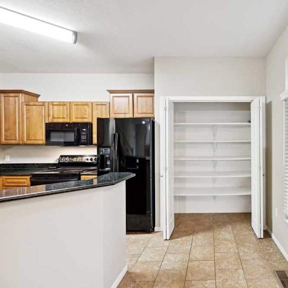 Thumbnail 8 of 25 Walk-in pantry with built-in shelving and tile flooring near kitchen.