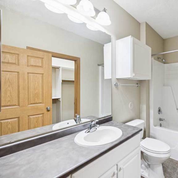 Thumbnail 15 of 21 Full bathroom with single-sink vanity, large mirror, linen cabinet, and tub-shower combination.