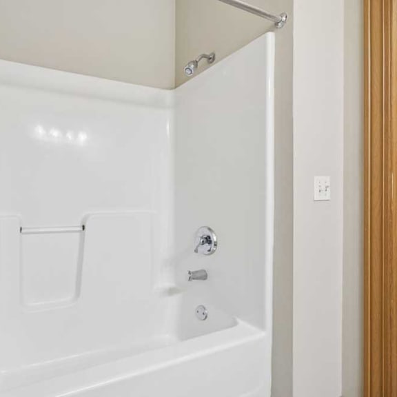 Thumbnail 21 of 21 Tub and shower combination with built-in shelving and chrome fixtures.