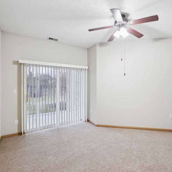 Thumbnail 12 of 21 Bright bedroom with large window, ceiling fan, and soft neutral finishes.