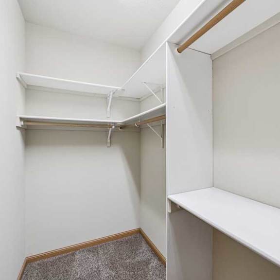 walk-in closet with built-in shelving, hanging rods, and additional storage space.