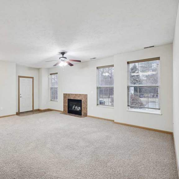 Thumbnail 5 of 21 Bright living area with multiple windows, neutral finishes, and fireplace with tile surround.