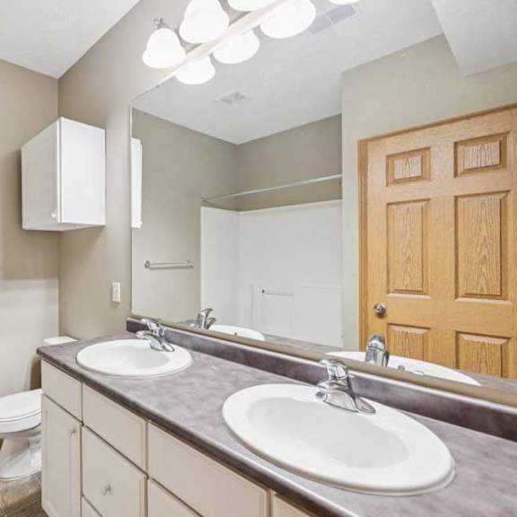 Thumbnail 14 of 20 Bathroom with double-sink vanity, extended countertop, large mirror, and tub and shower combination with tile-look flooring.