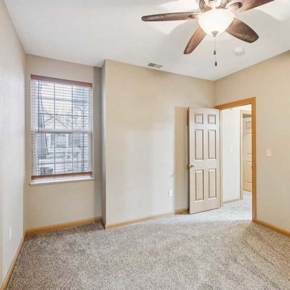 Thumbnail 16 of 20 Secondary bedroom with plush carpet, ceiling fan, window with blinds, and wood-trimmed door.