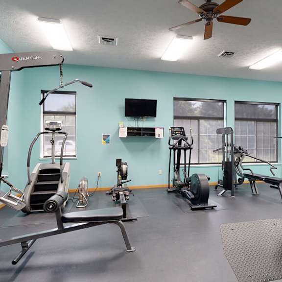 24 hour fitness center with exercise equipment and a flat screen tv