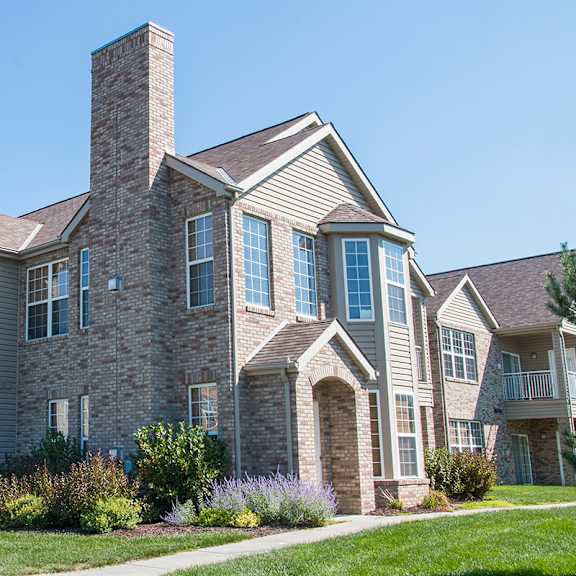 a villa building with brick and stone exterior on a sunny day