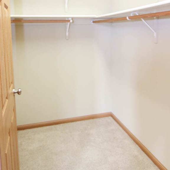 Thumbnail 12 of 12 a walk in closet with white walls and a wooden door