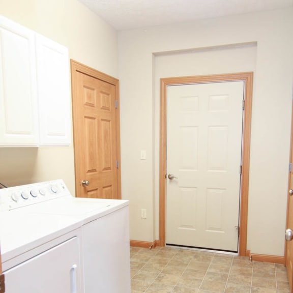 Thumbnail 7 of 12 an empty laundry room with a white washer and dryer