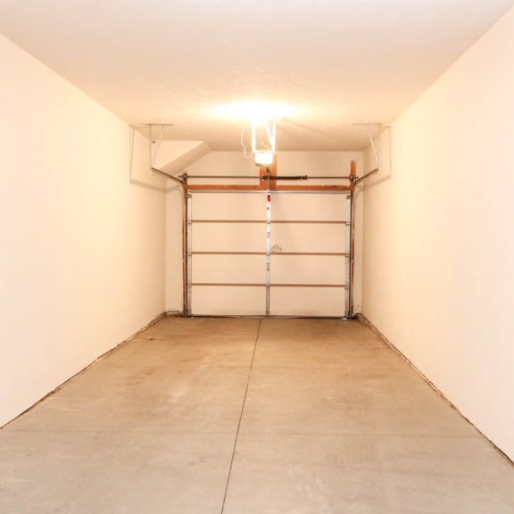 Thumbnail 9 of 12 an empty garage with a white wall and a white garage door