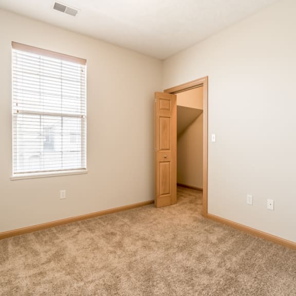 Thumbnail 11 of 12 an empty bedroom with a door to a closet and a window