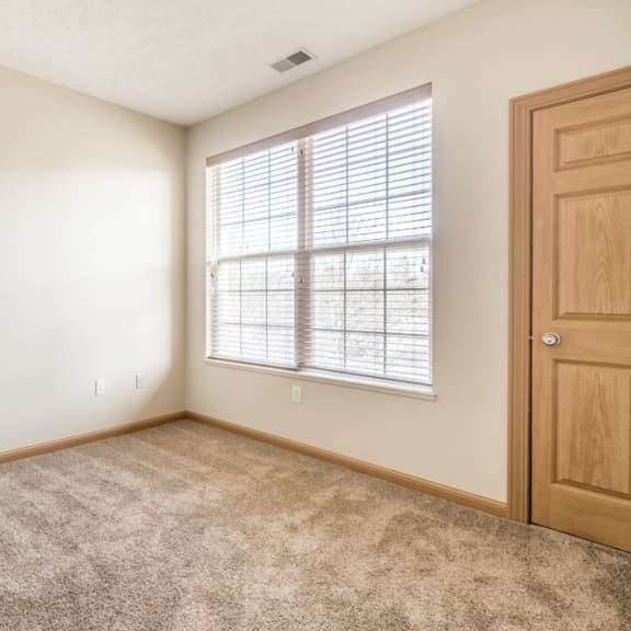 Thumbnail 2 of 12 an empty room with a window and a door